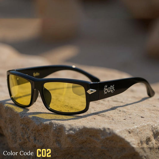 Black sunglasses with yellow lenses on a stone surface, brand 'Surfex' visible