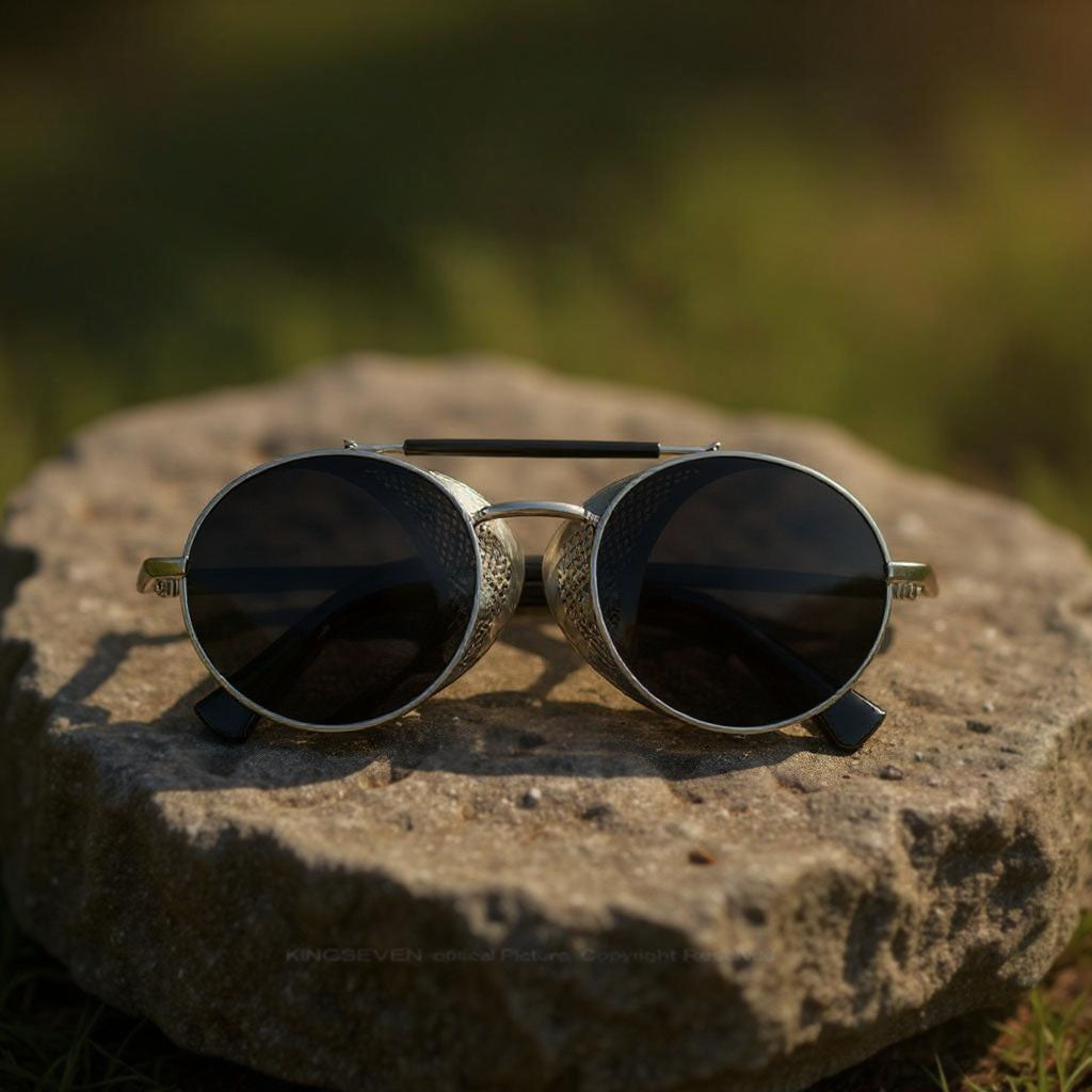 Round sunglasses with metallic frame on a stone surface with a blurred natural background
