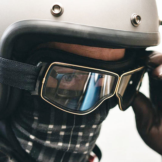 Person wearing a helmet with reflective goggles and plaid scarf