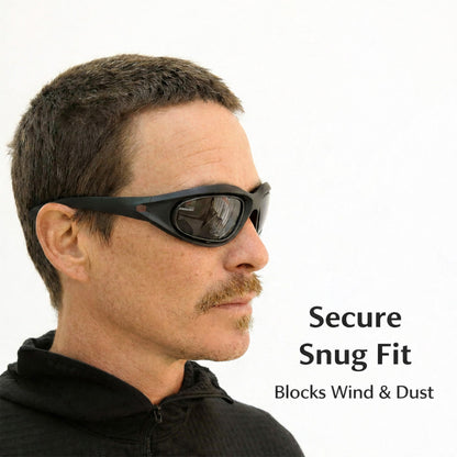 Man wearing black polarized motorcycle sunglasses with text 'Secure Snug Fit' and 'Blocks Wind & Dust' on a white background